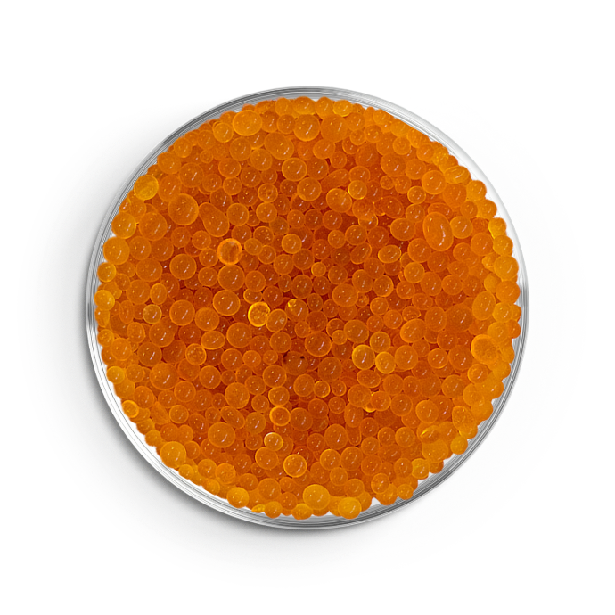 Orange silica gel beads in petri dish